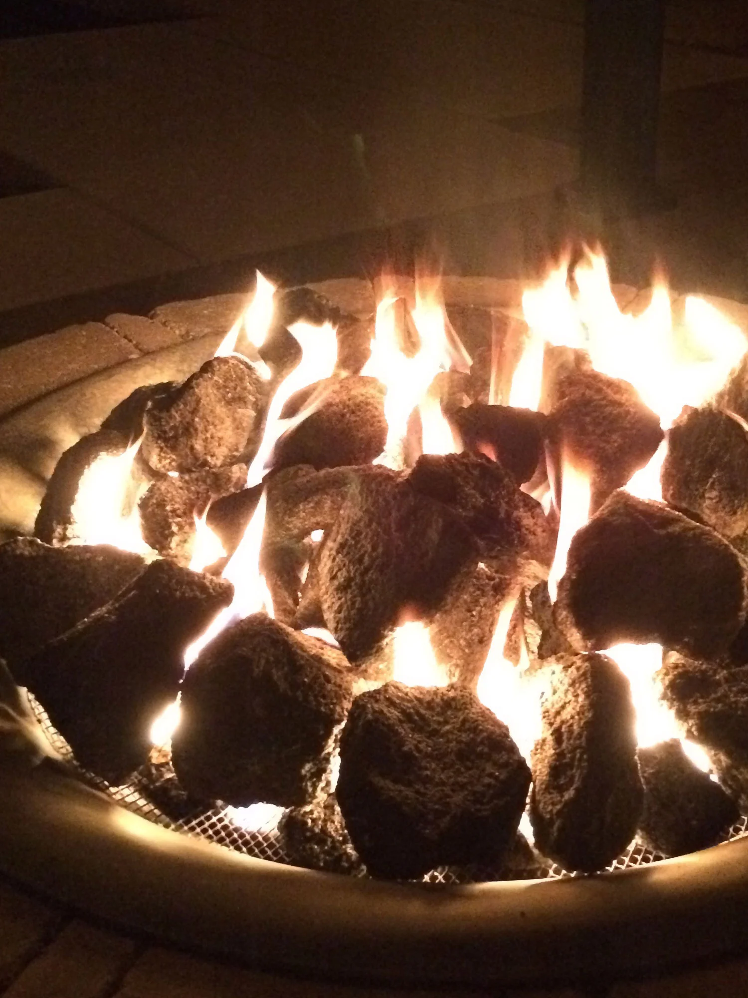 Our backyard DIY liquid propane fire pit complete with tank-cloking mini outhouse and feather rock lava stones to help radiate some of that magnificent clean heat