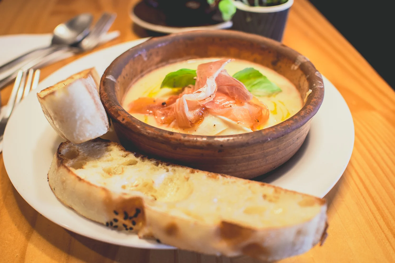 Baked Eggs - Contadino Two poached eggs in a bed of creamy cannellini beans with Italian pork and fennel sausage finished with fresh prosciutto and basil served with bread - $15