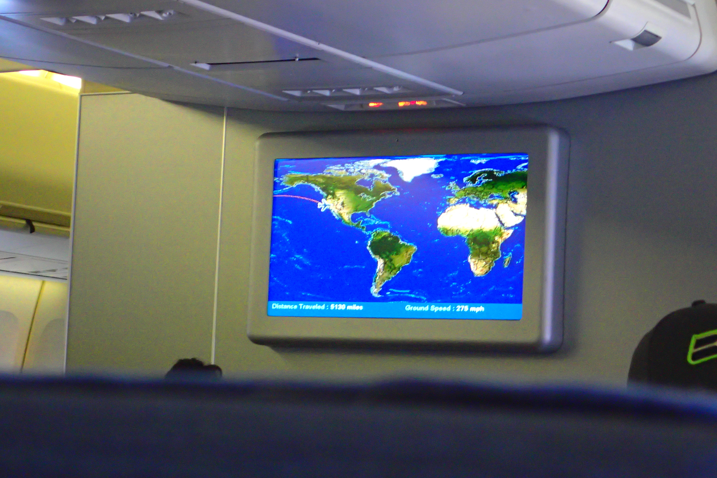 Peering over the airline seats at the world map