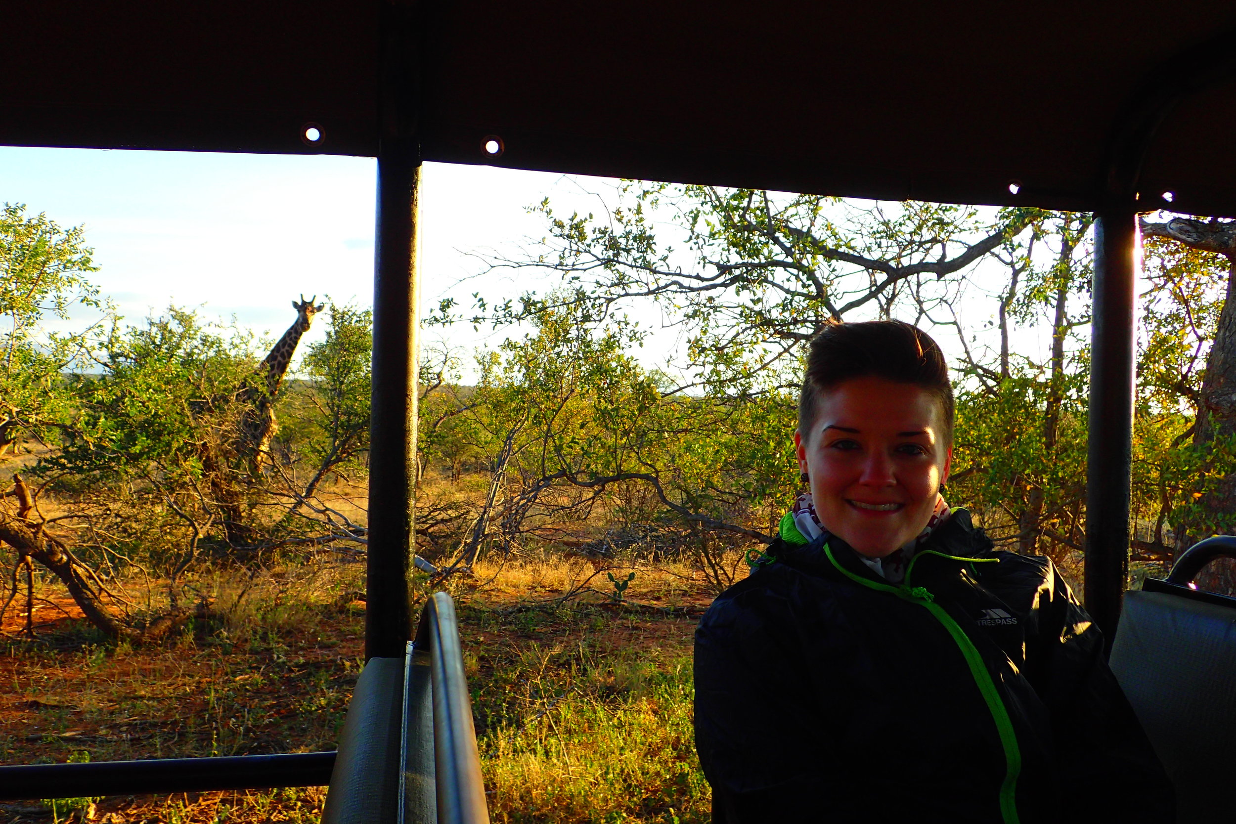 Posing with a wild giraffe while on safari