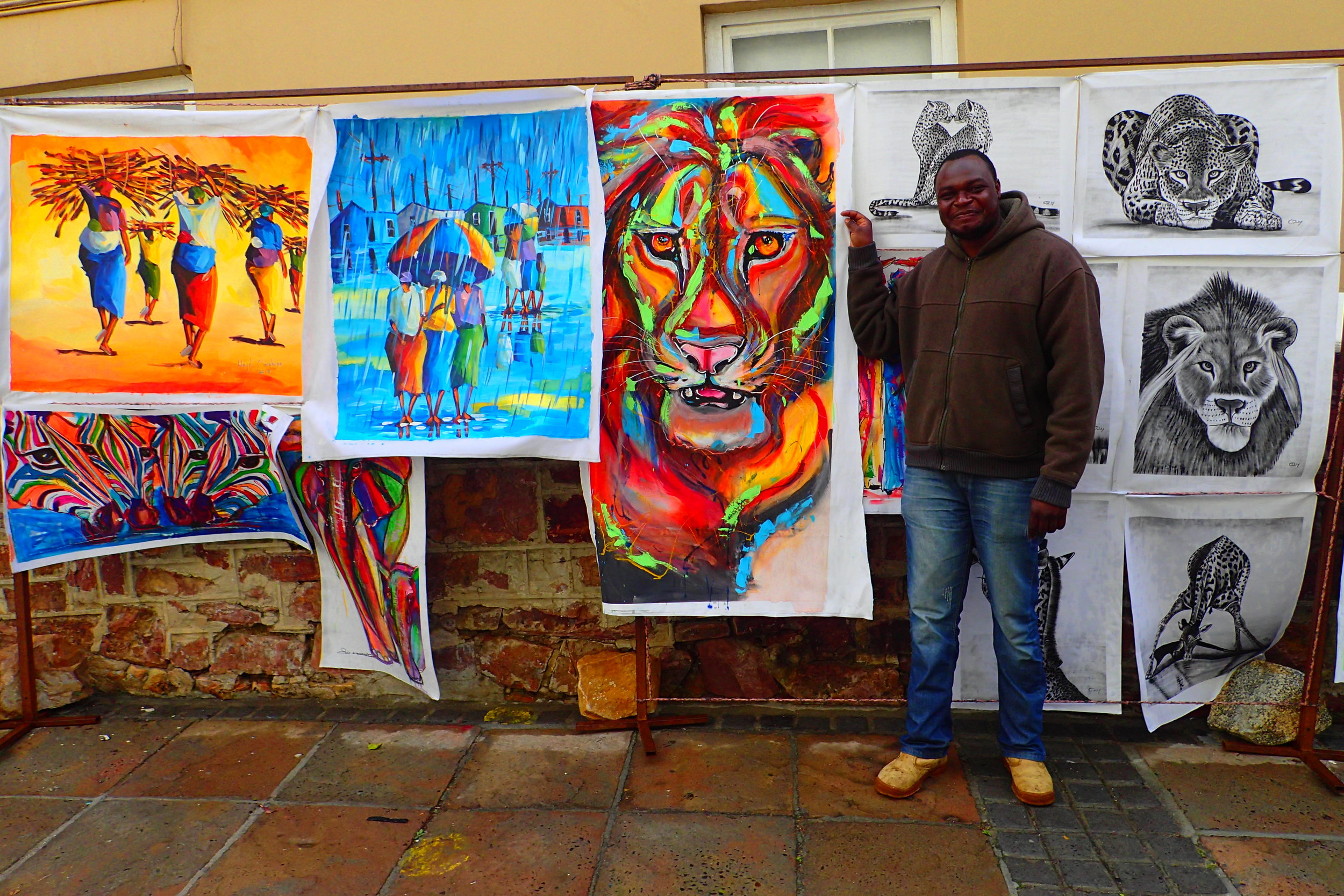 Asanoo posing with his and his brother’s artwork