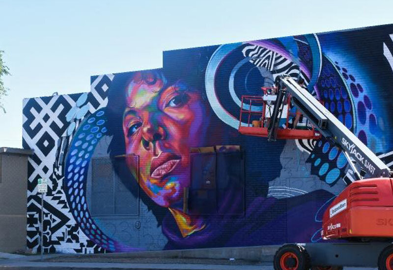 Mural in the city of Aurora highlights a local Peruvian immigrant seamstress in a collaboration by artists Detour, Anna Charney and A.L. Grime. Image Colorado Tourism