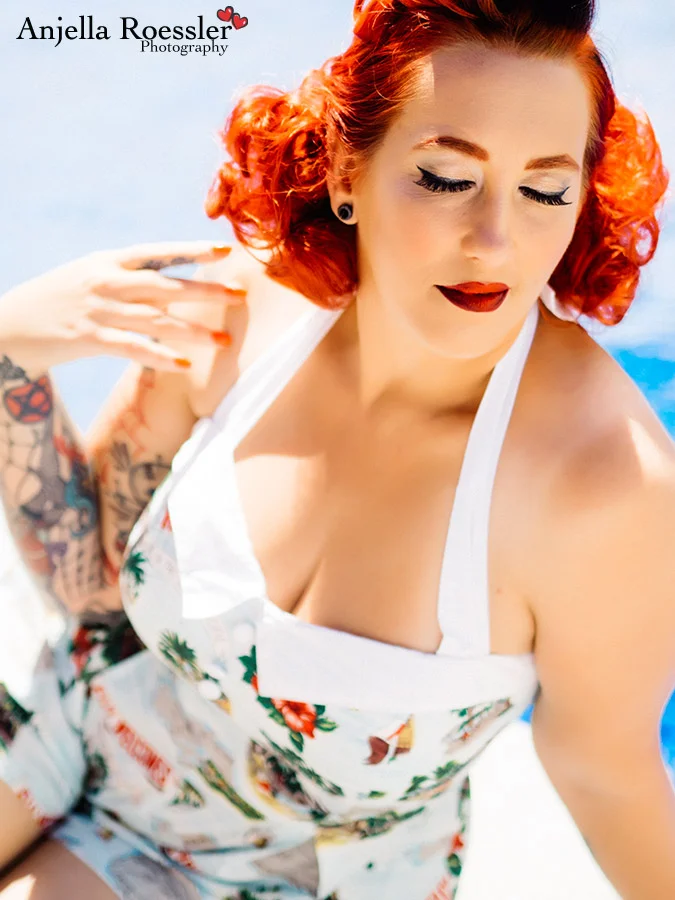 EveElle Scarlett relaxing by the pool in a Hellbunny jumpsuit