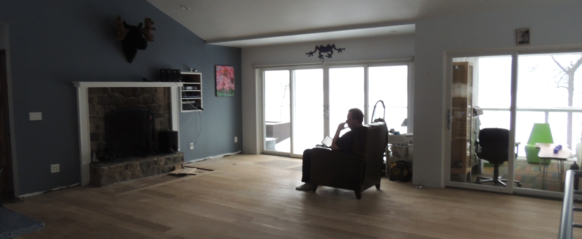 Looking a tad forlorn, my husband enjoys the last piece of furniture remaining in the great room prior to the sanding, staining and sealing of the floors.