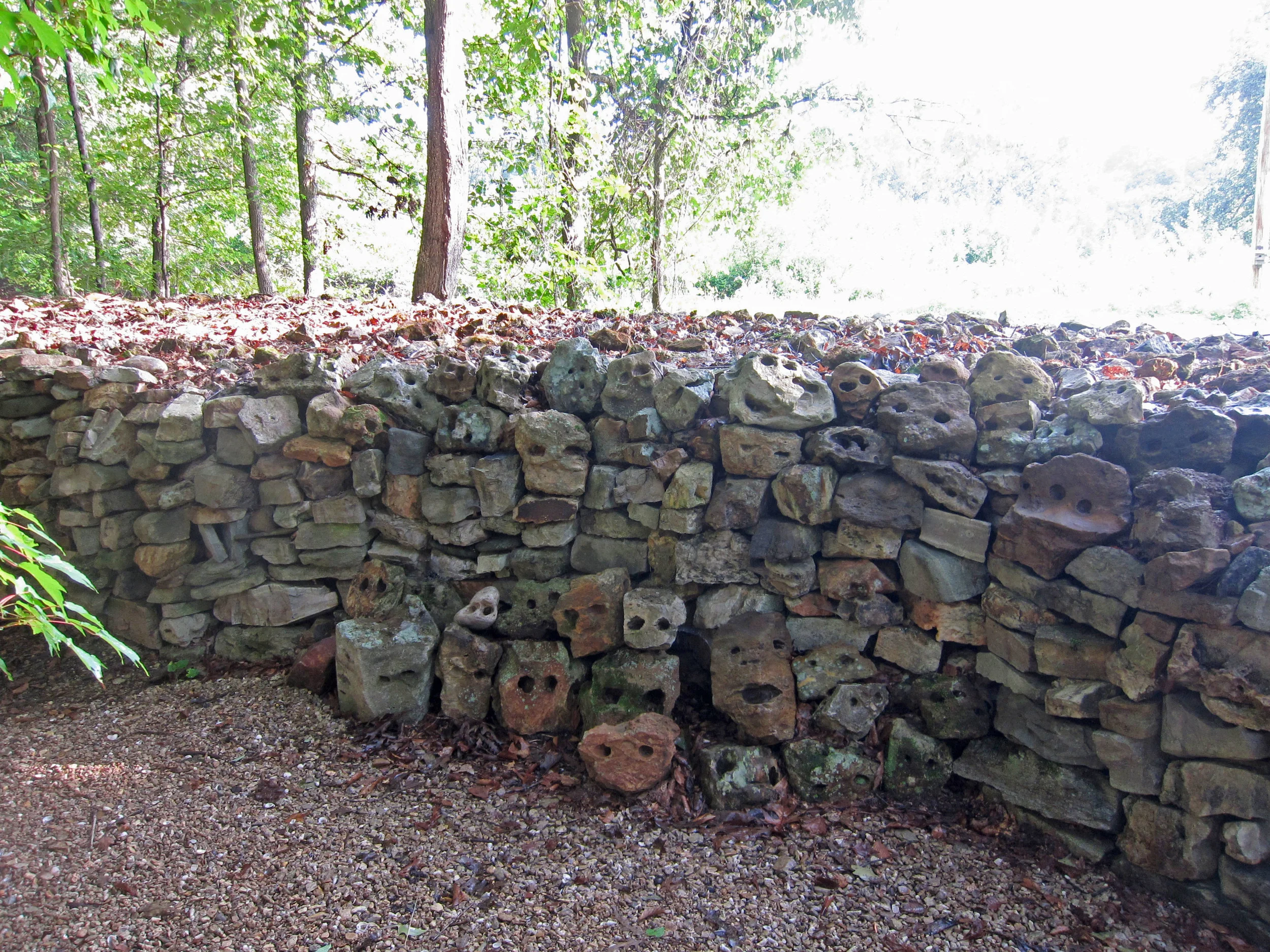 Tom’s great-great grandmother, Te-lah-ney was born in the Tennessee Valley in the early 1800s. The Yuchi believed that a woman lived in the Tennessee River and sang to them. The Wall meanders just as Te-lah-ney’s journey did and there are many surprises. I stopped first at a ten-foot section of the wall built with river rocks that look like faces. The “eyes” that look out at you are natural holes worn in soft limestone from centuries of bumping along at the edge of the Tennessee River. I sat on the stone bench opposite and gazed at the “faces” which were initially haunting but after a few minutes I felt curiously happy. The Lakota people who modified this section of the Wall told Tom that all bad things come out of the west, so they positioned the rock faces facing west, saying they would protect Te-lah-ney’s Wall. 