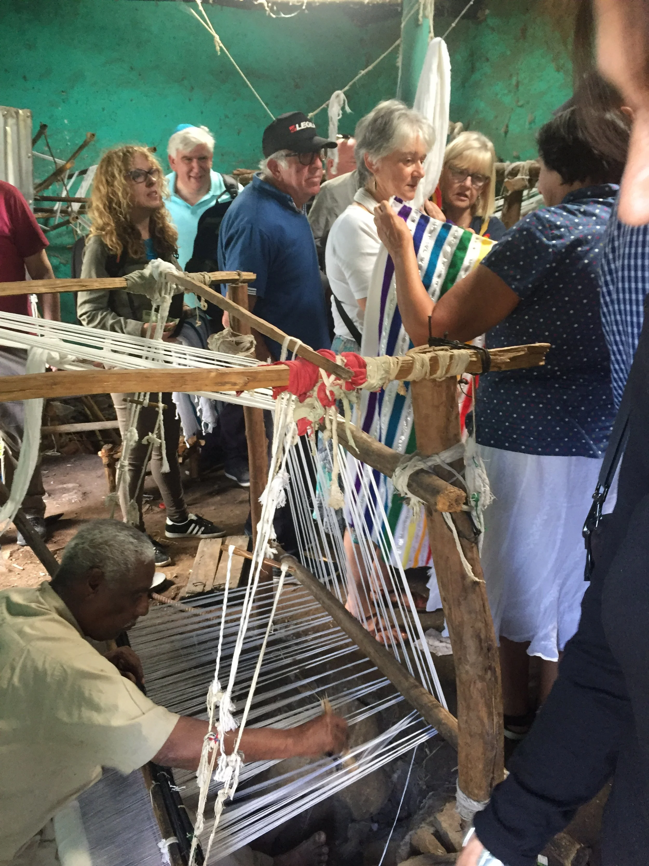 Our group tries on Tallitot made by the Jewish Weavers.JPG
