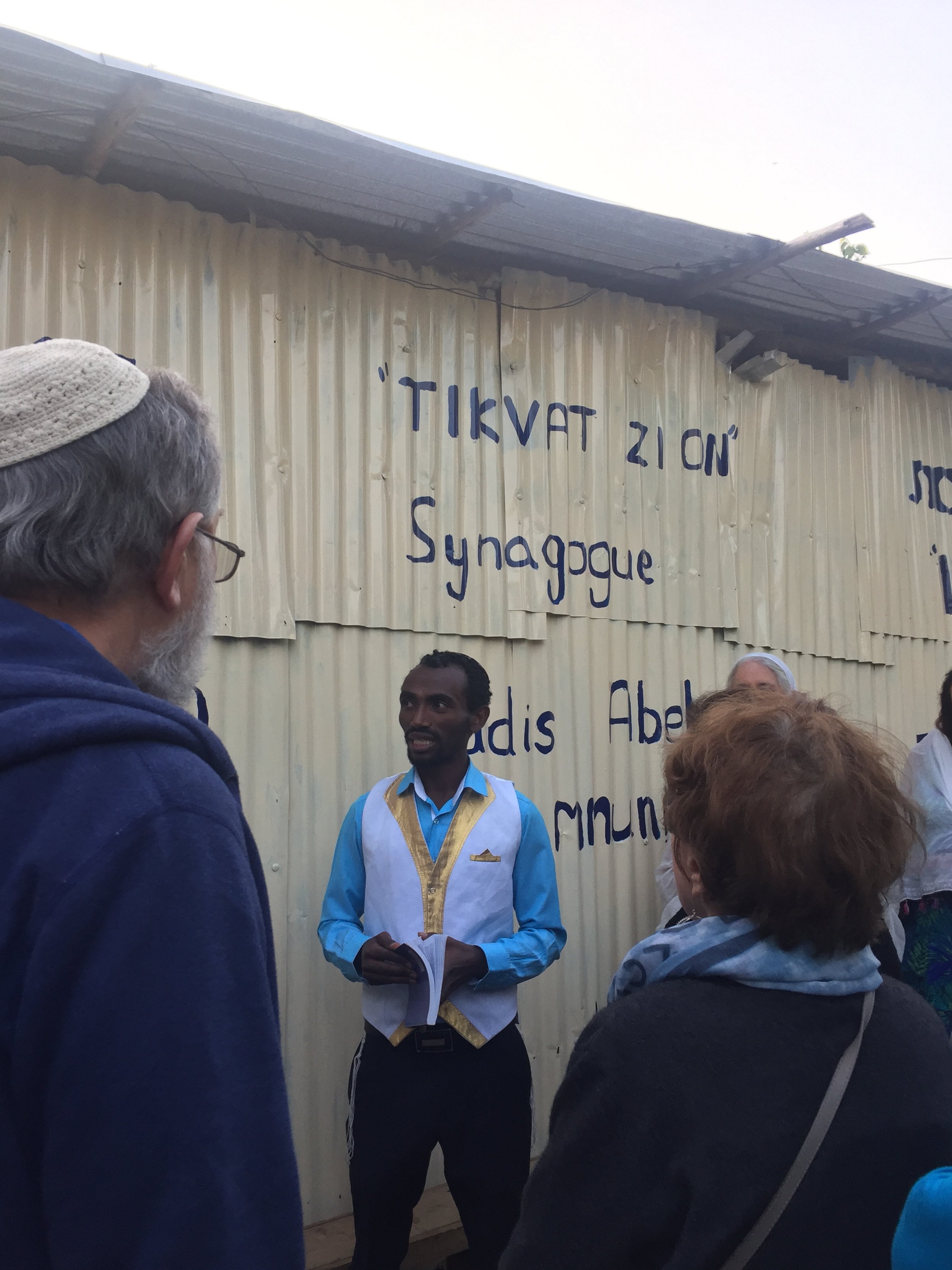 Our host explains the community's story at Tikvat Zion synagogue, Addis.JPG