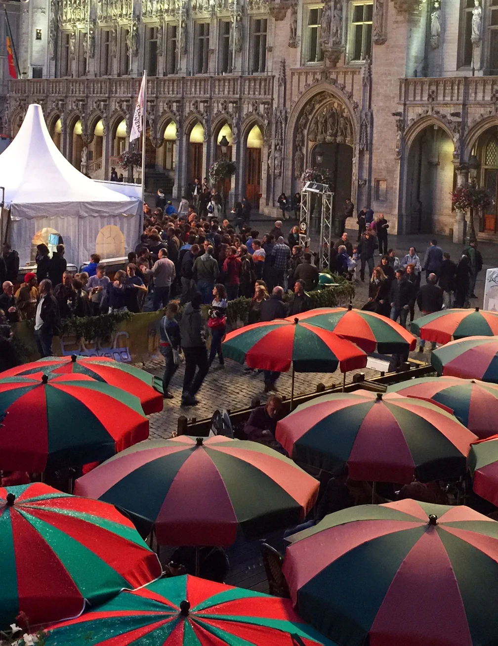 Restaurant umbrellas, beer booth tents, and boulevardiers in front of the Brussels city hall