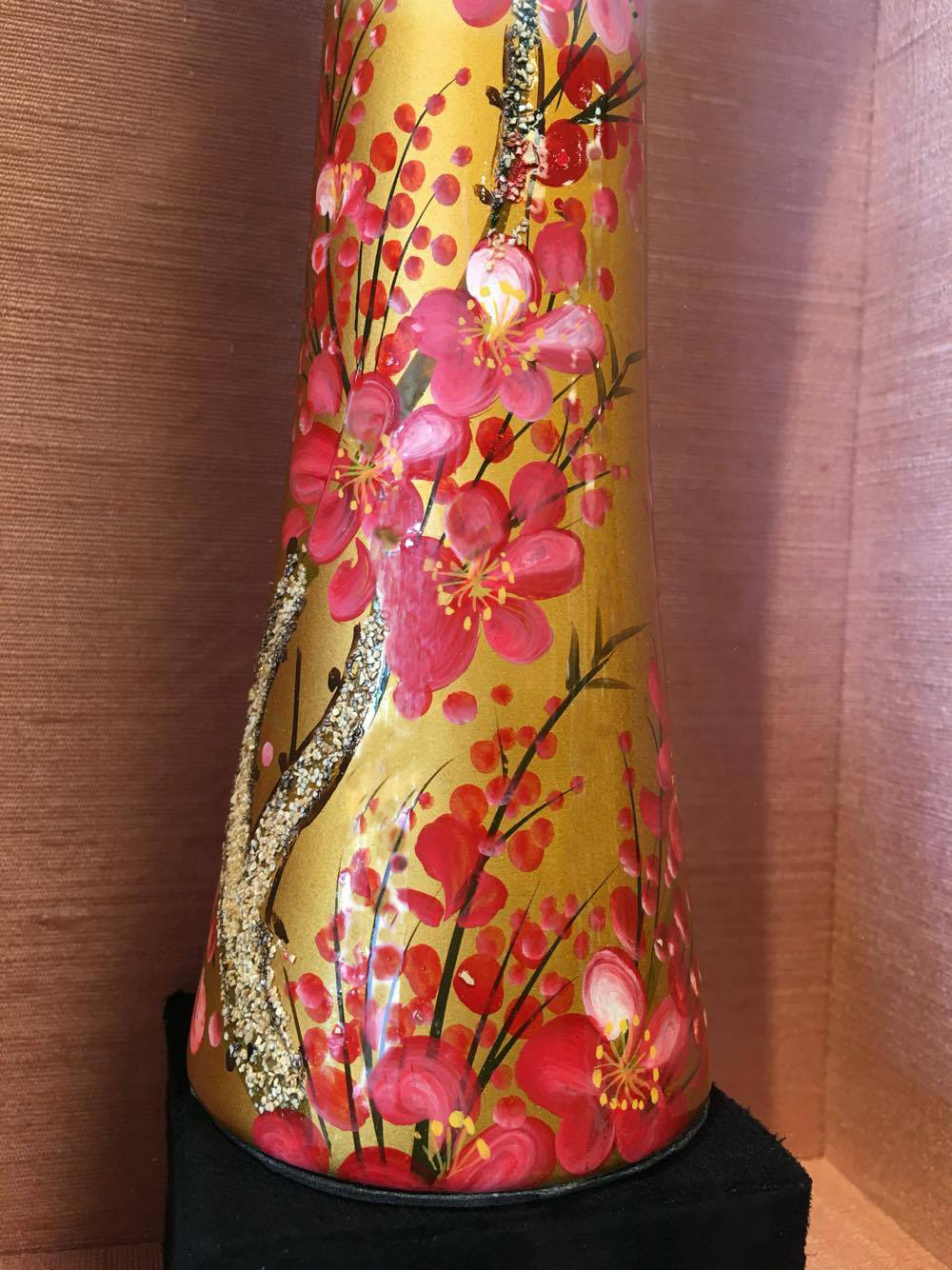 A close up of the vase's detail against the silk fabric. 