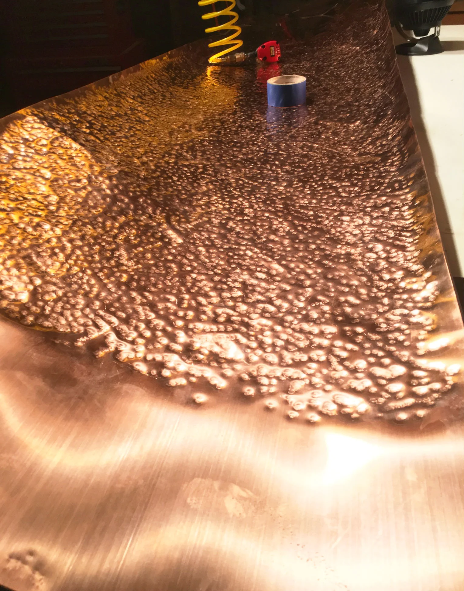 Kruger hand-pounding the sheet of copper that will wrap around the client's kitchen counter. 