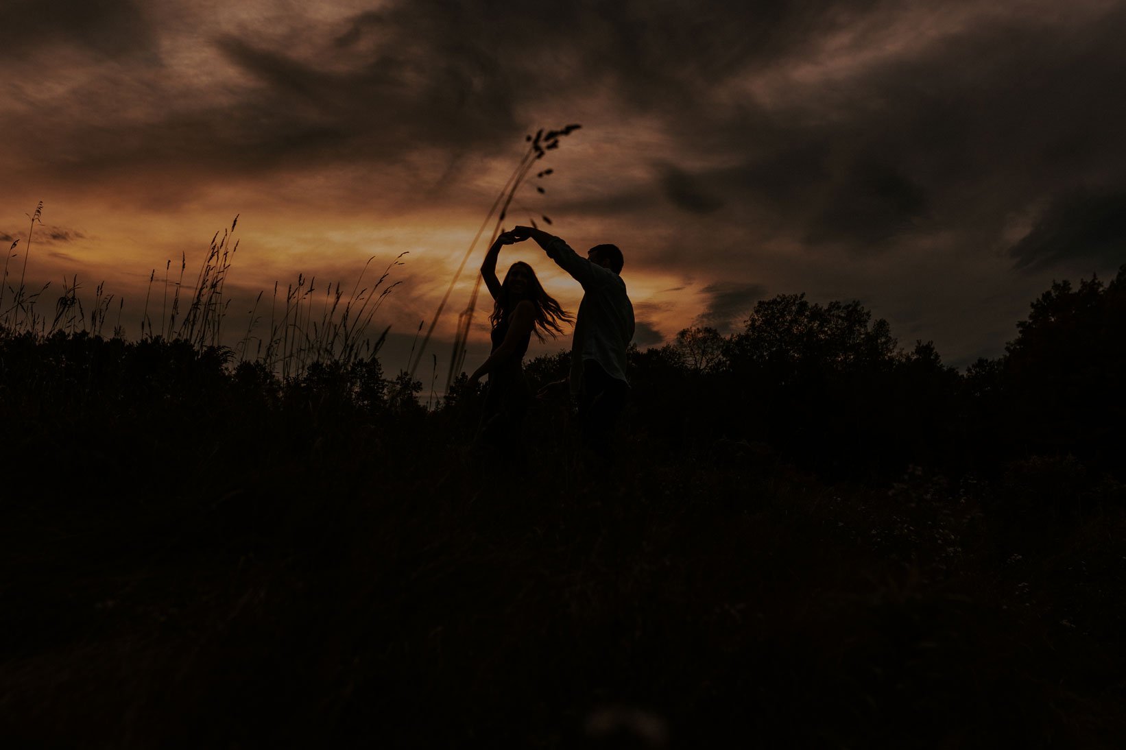 Engagement photo of couple dancing in sunset