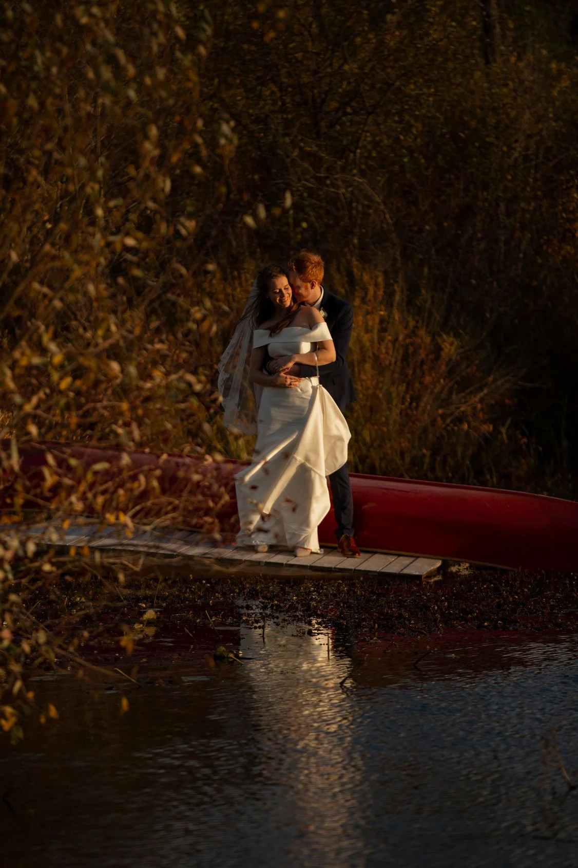 bride and groom by pond