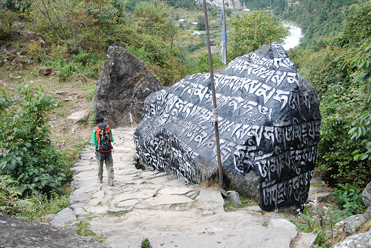 Trailside boulder carved with Buddhist prayers