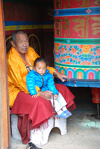 Sherpa and granddaughter turn a prayer wheel