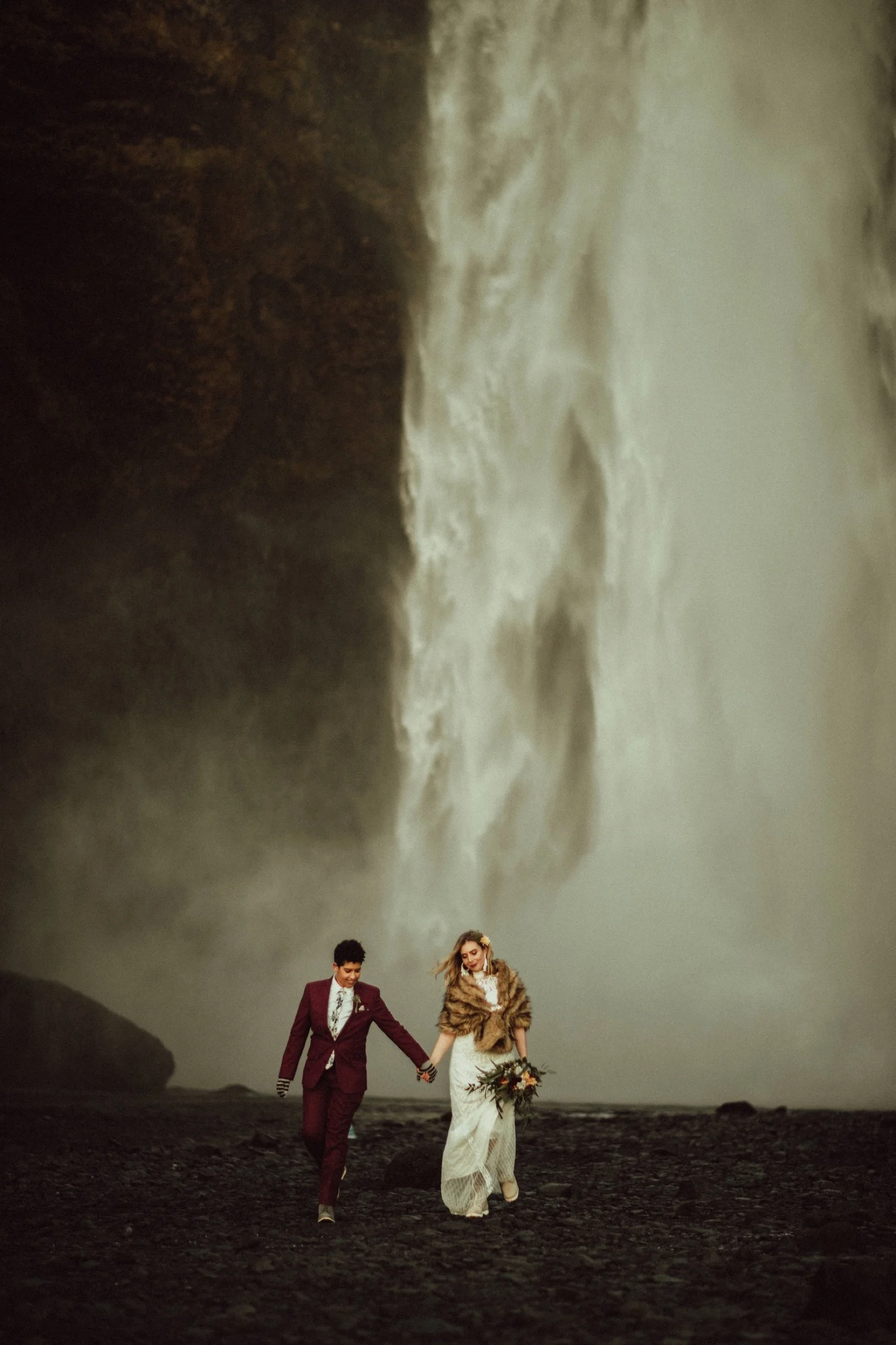 queer iceland elopement in front of waterfall by iceland elopement planner steph zakas