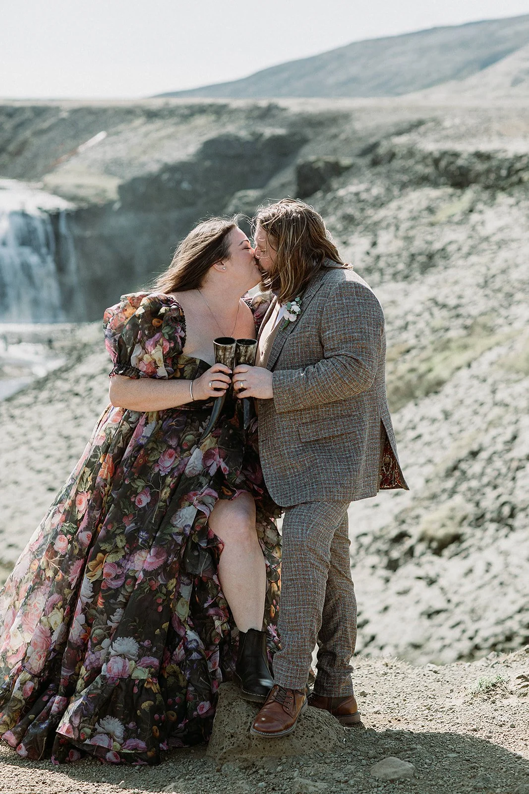 private Iceland elopement in black wedding dress at waterfall kissing