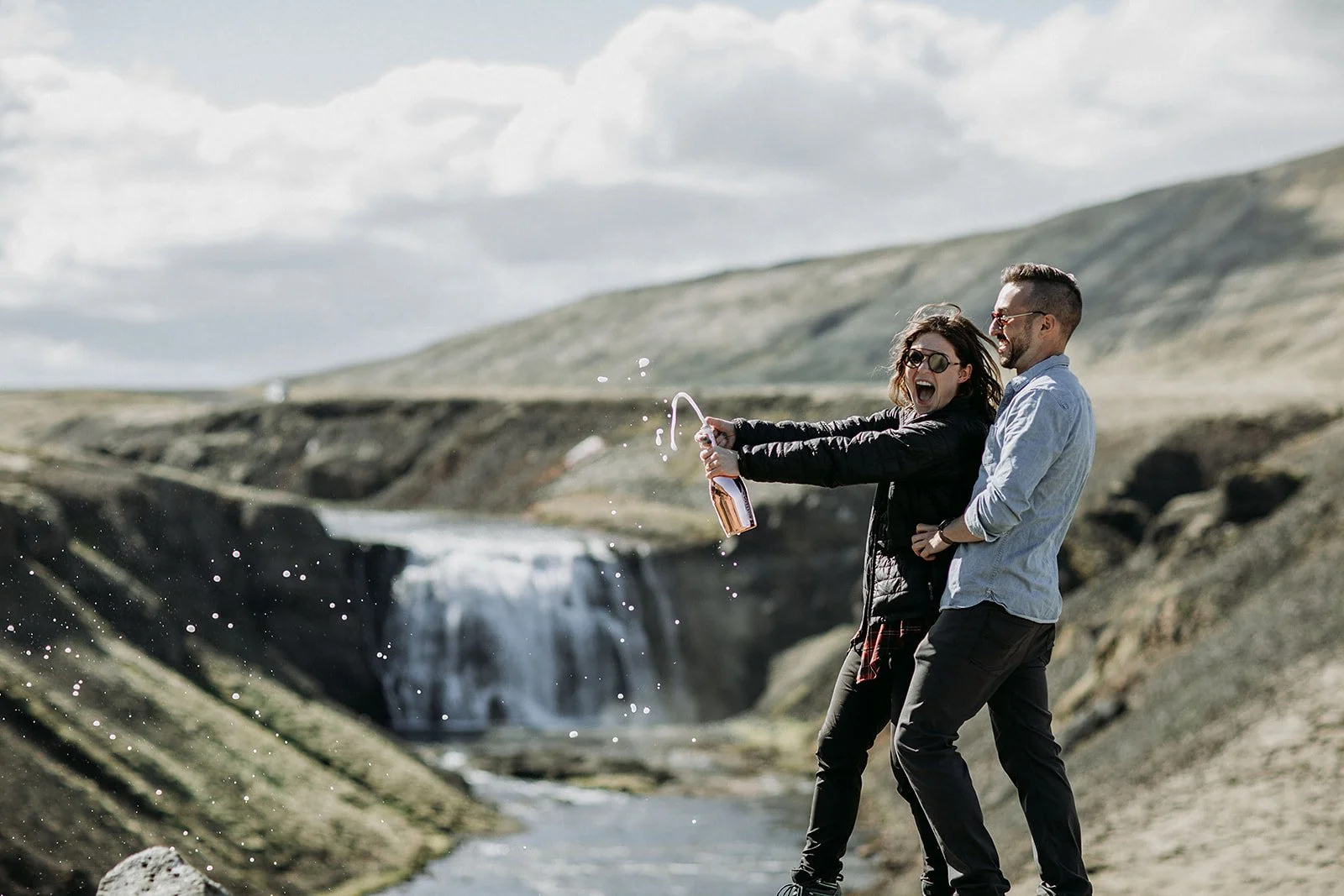 private Iceland proposal at waterfall champagne pop in front of waterfall