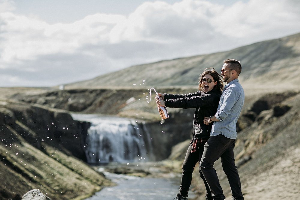 private Iceland proposal at waterfall champagne pop in front of waterfall