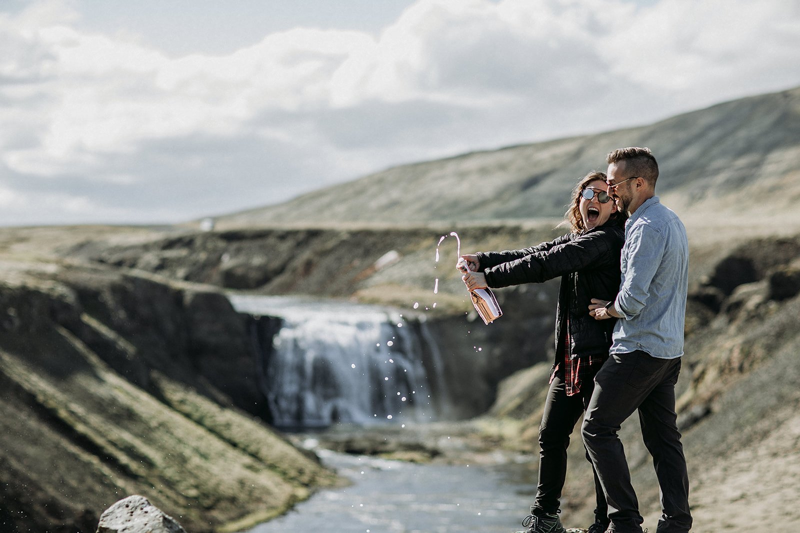 private Iceland proposal at waterfall champagne pop in front of waterfall