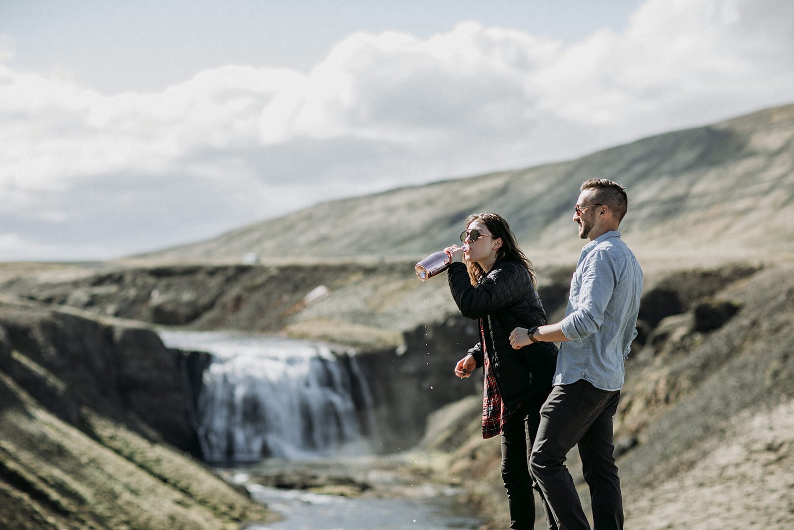 private Iceland proposal at waterfall champagne pop in front of waterfall
