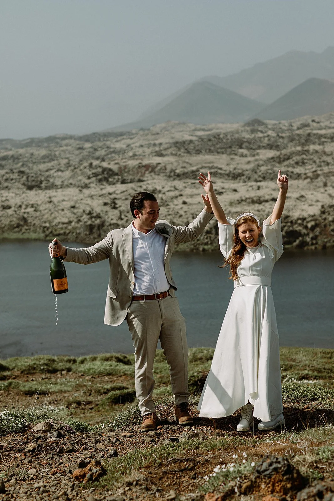 Iceland elopement in secluded area with couple popping champagne by Iceland elopement planner Steph zakas
