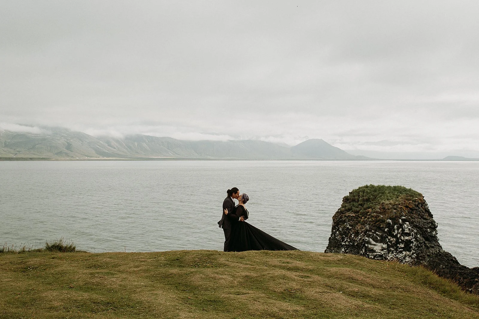 Alternative Iceland elopement couple wearing black wedding dress and purple hair — couple portraits