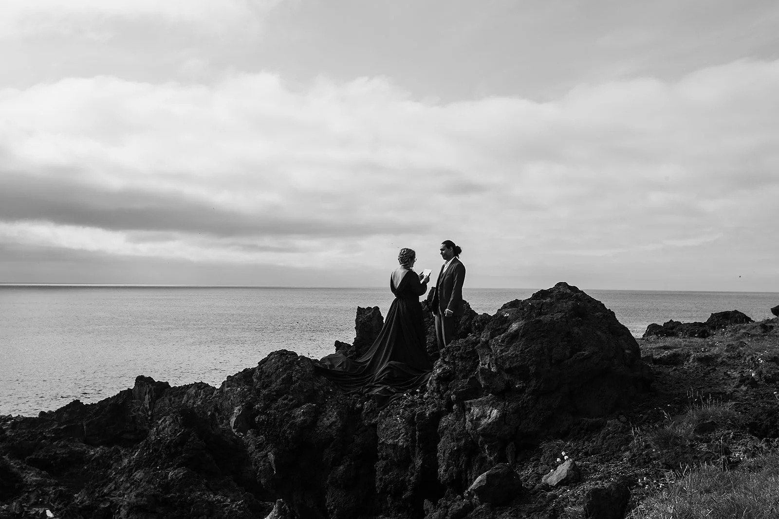 Alternative Iceland elopement couple wearing black wedding dress and purple hair — couple saying vows wedding ceremony