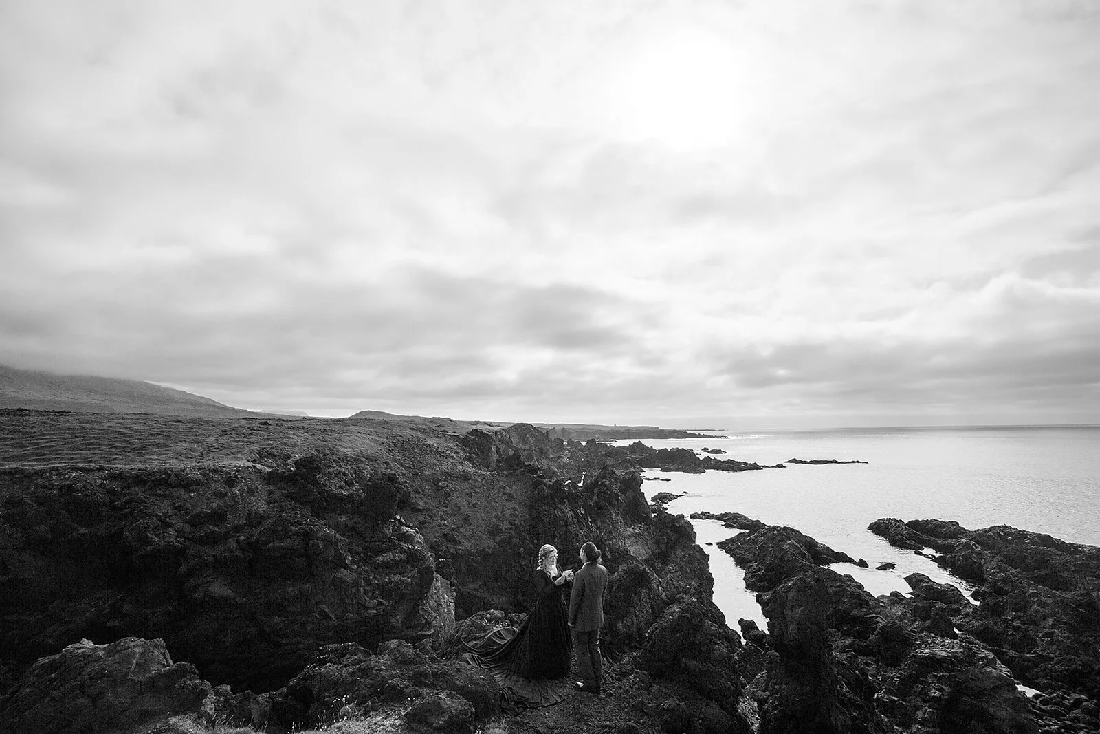 Alternative Iceland elopement couple wearing black wedding dress and purple hair — couple portraits sea cliffs Snæfellsnes