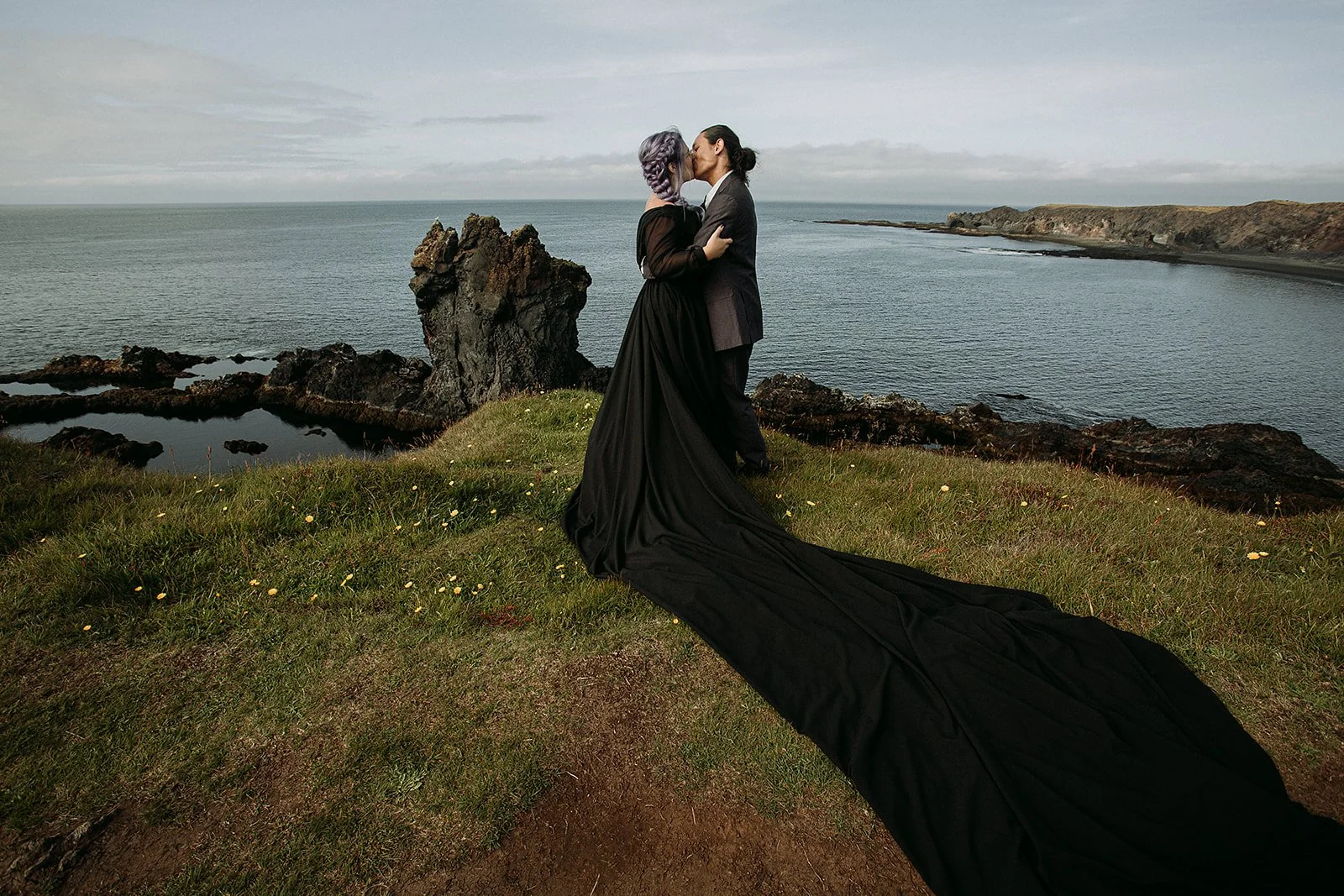 Alternative Iceland elopement couple wearing black wedding dress and purple hair — couple portraits at black sand beach