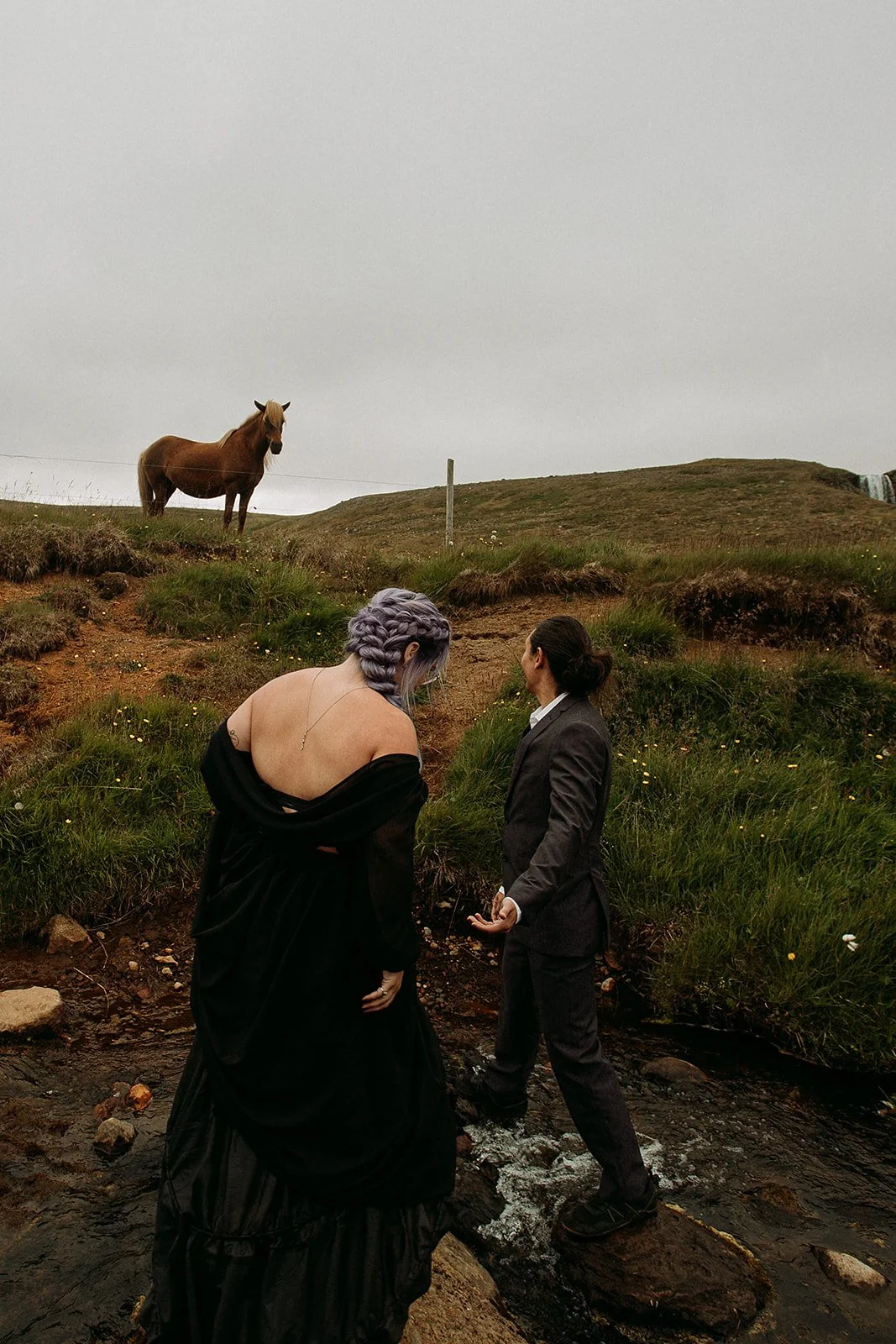 Alternative Iceland elopement couple wearing black wedding dress and purple hair — couple portraits Kirkfjufell