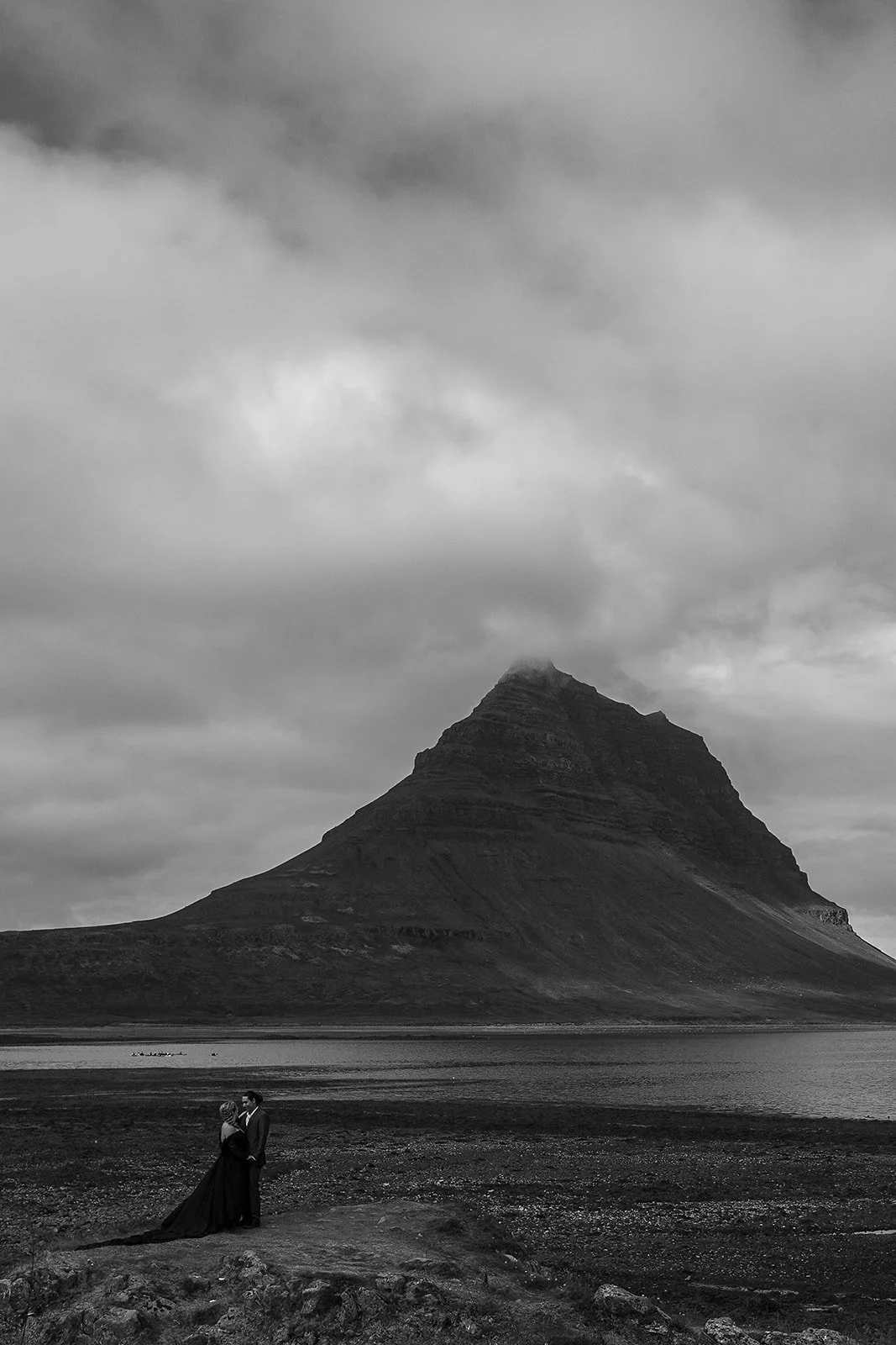 Alternative Iceland elopement couple wearing black wedding dress and purple hair — couple portraits Kirkfjufell