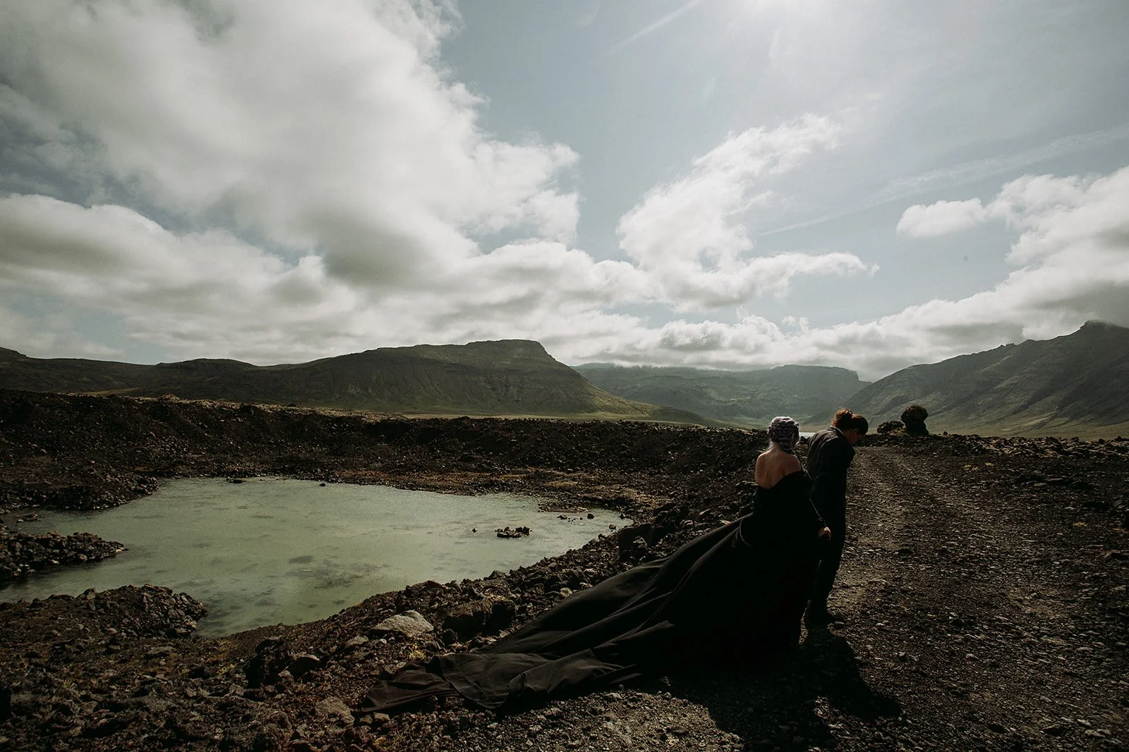 Alternative Iceland elopement couple wearing black wedding dress and purple hair — couple portraits at mountains