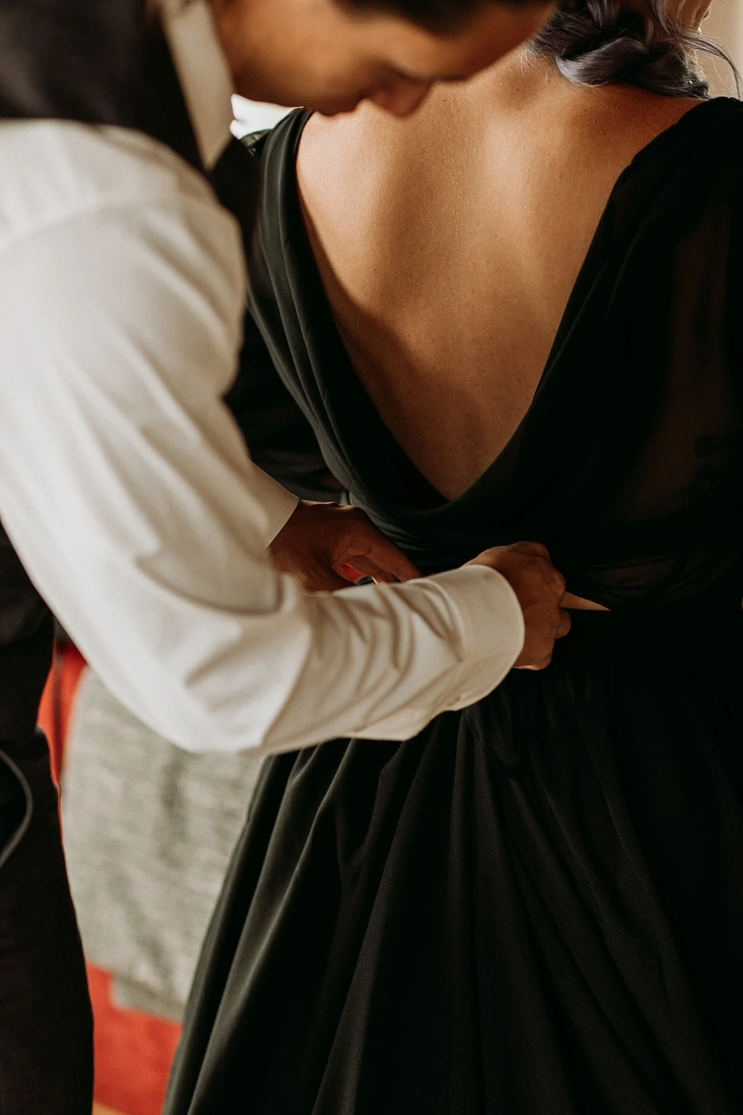 Alternative Iceland elopement couple wearing black wedding dress and purple hair — getting ready for the elopement 