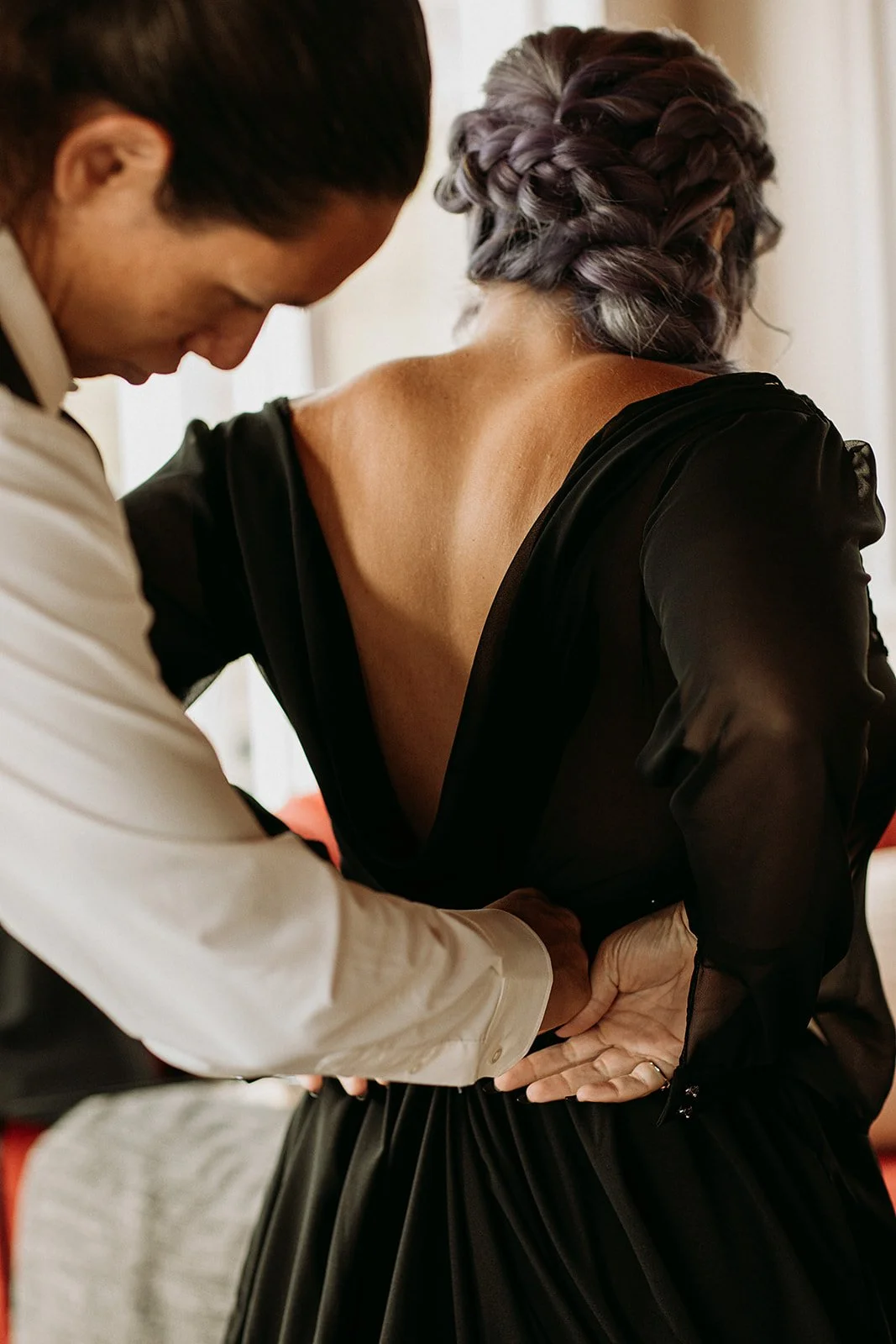 Alternative Iceland elopement couple wearing black wedding dress and purple hair — getting ready for the elopement 