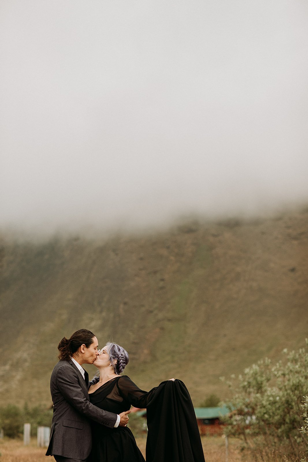 Alternative Iceland elopement couple wearing black wedding dress and purple hair — couples adventure photos