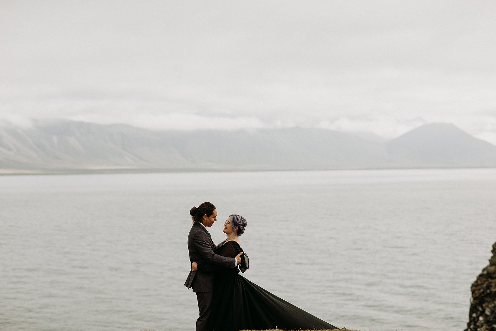 Alternative Iceland elopement couple wearing black wedding dress and purple hair — couple portraits