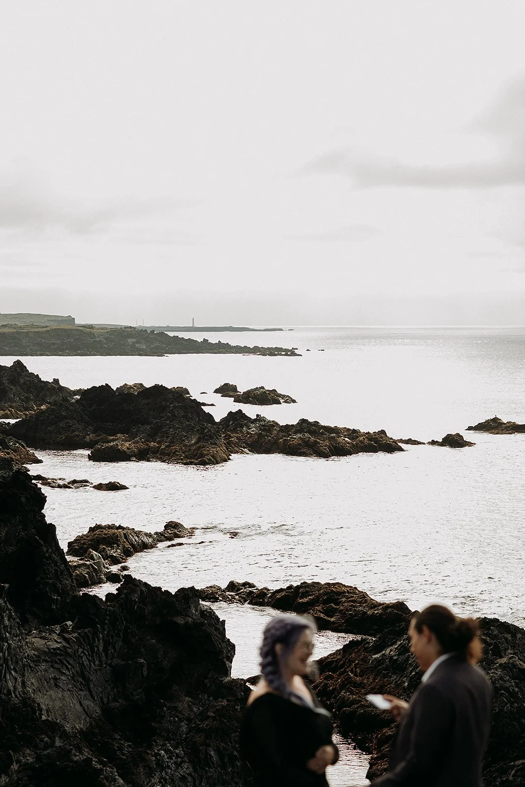 Alternative Iceland elopement couple wearing black wedding dress and purple hair — couple saying vows wedding ceremony