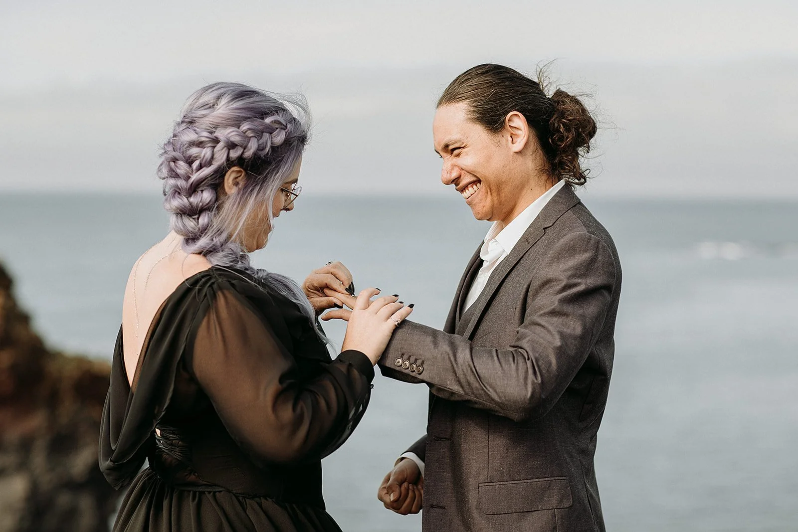 Alternative Iceland elopement couple wearing black wedding dress and purple hair — couple saying vows wedding ceremony