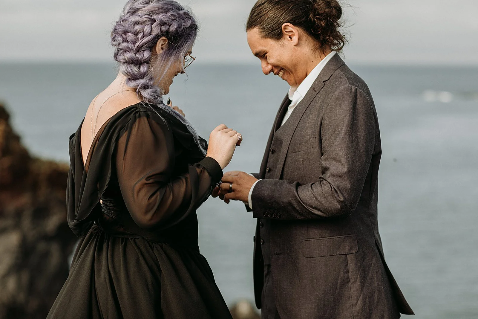 Alternative Iceland elopement couple wearing black wedding dress and purple hair — couple saying vows wedding ceremony