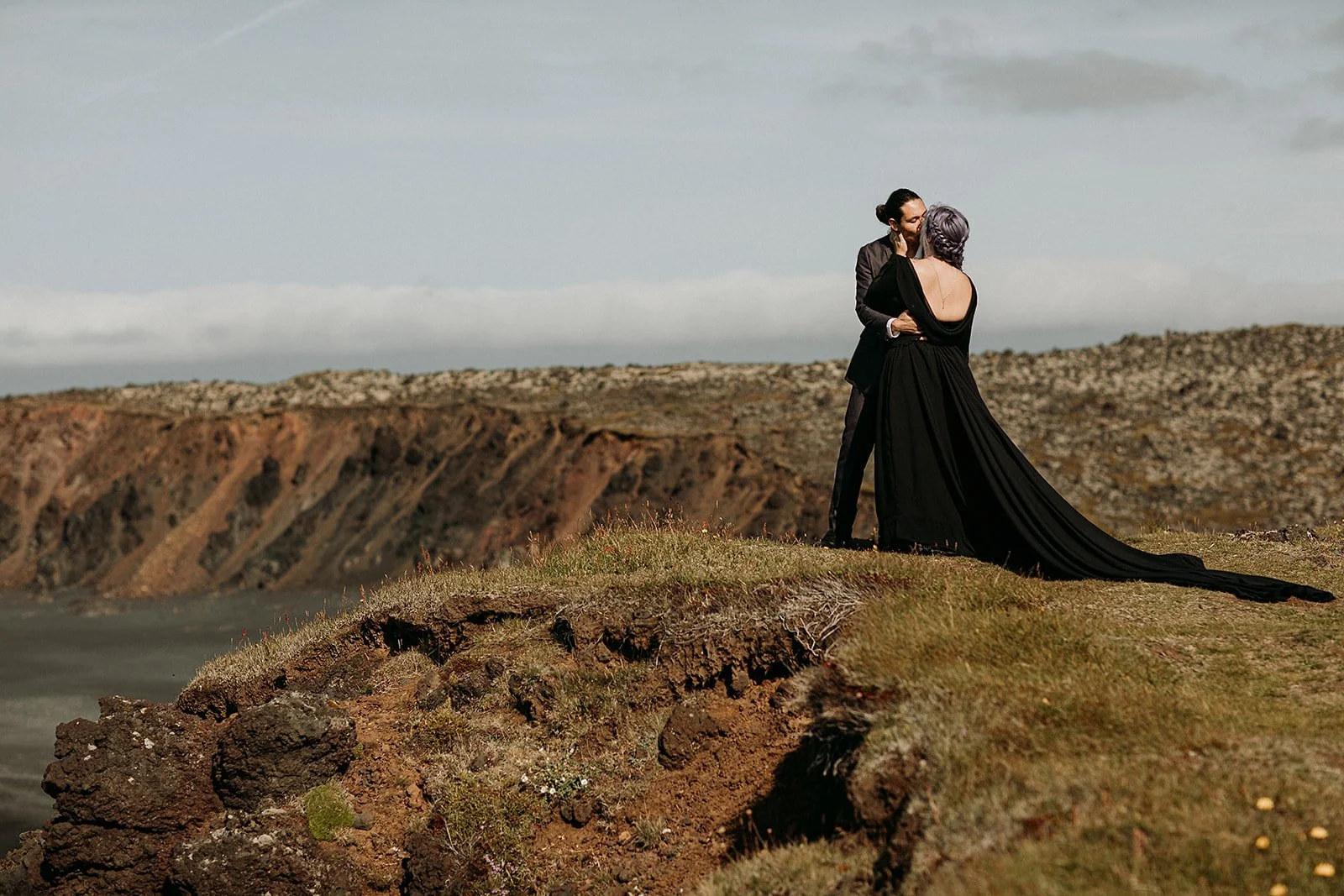 Alternative Iceland elopement couple wearing black wedding dress and purple hair — couple portraits