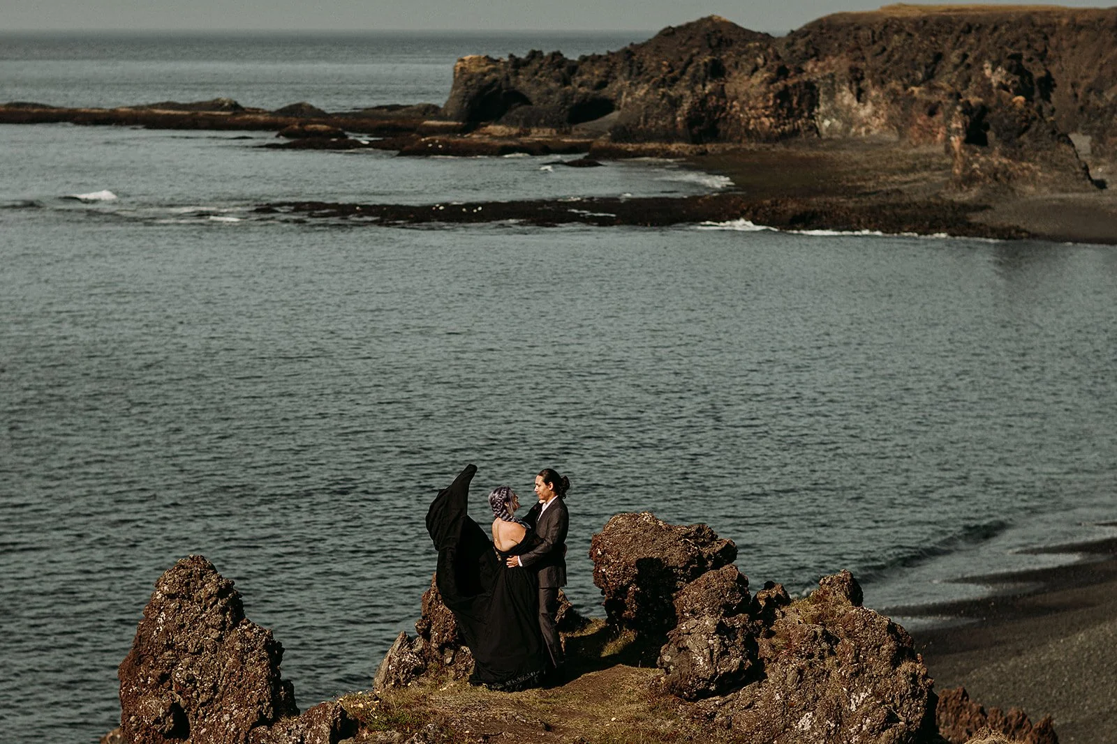 Alternative Iceland elopement couple wearing black wedding dress and purple hair — couple portraits black sand beach