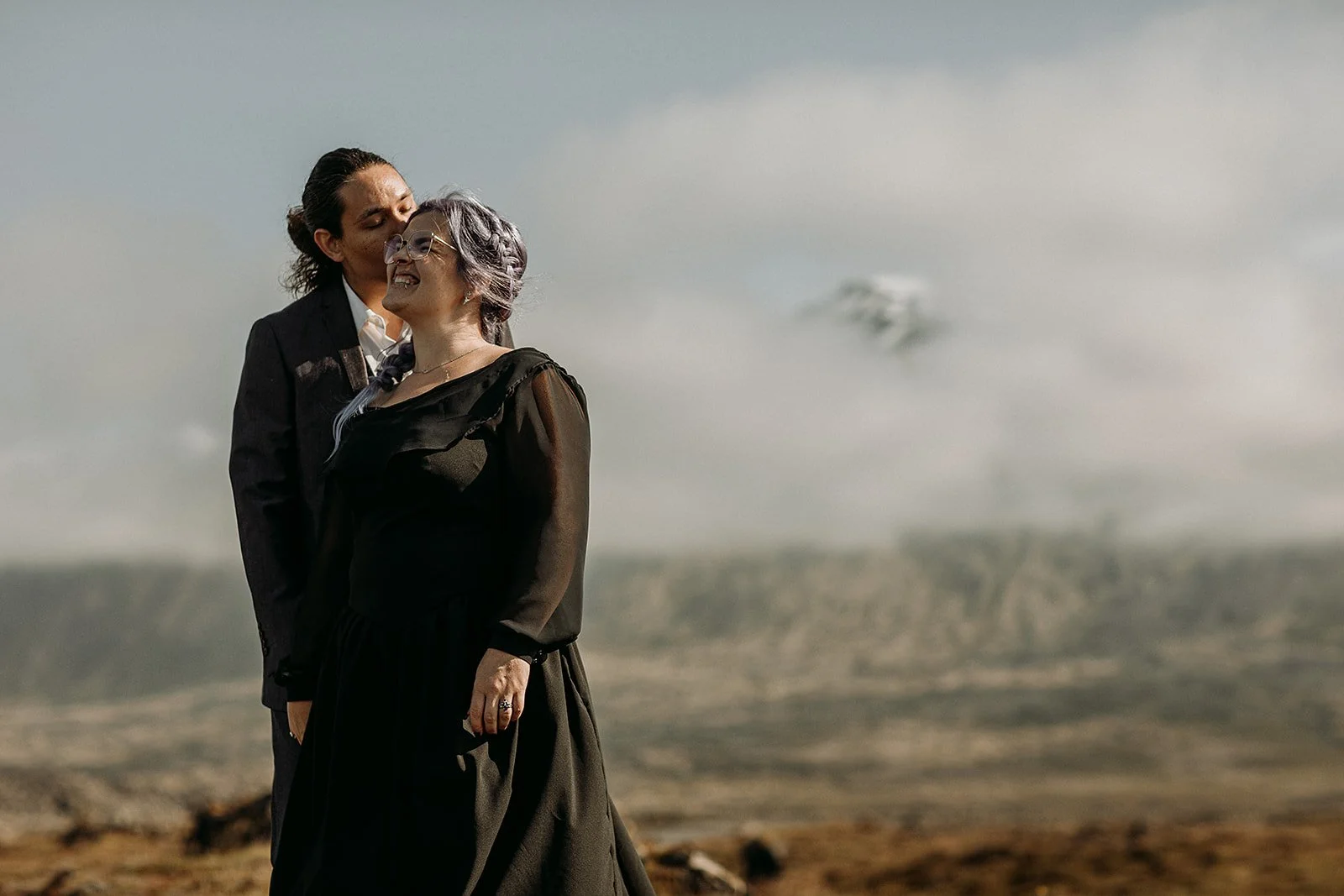 Alternative Iceland elopement couple wearing black wedding dress and purple hair — couples adventure photos