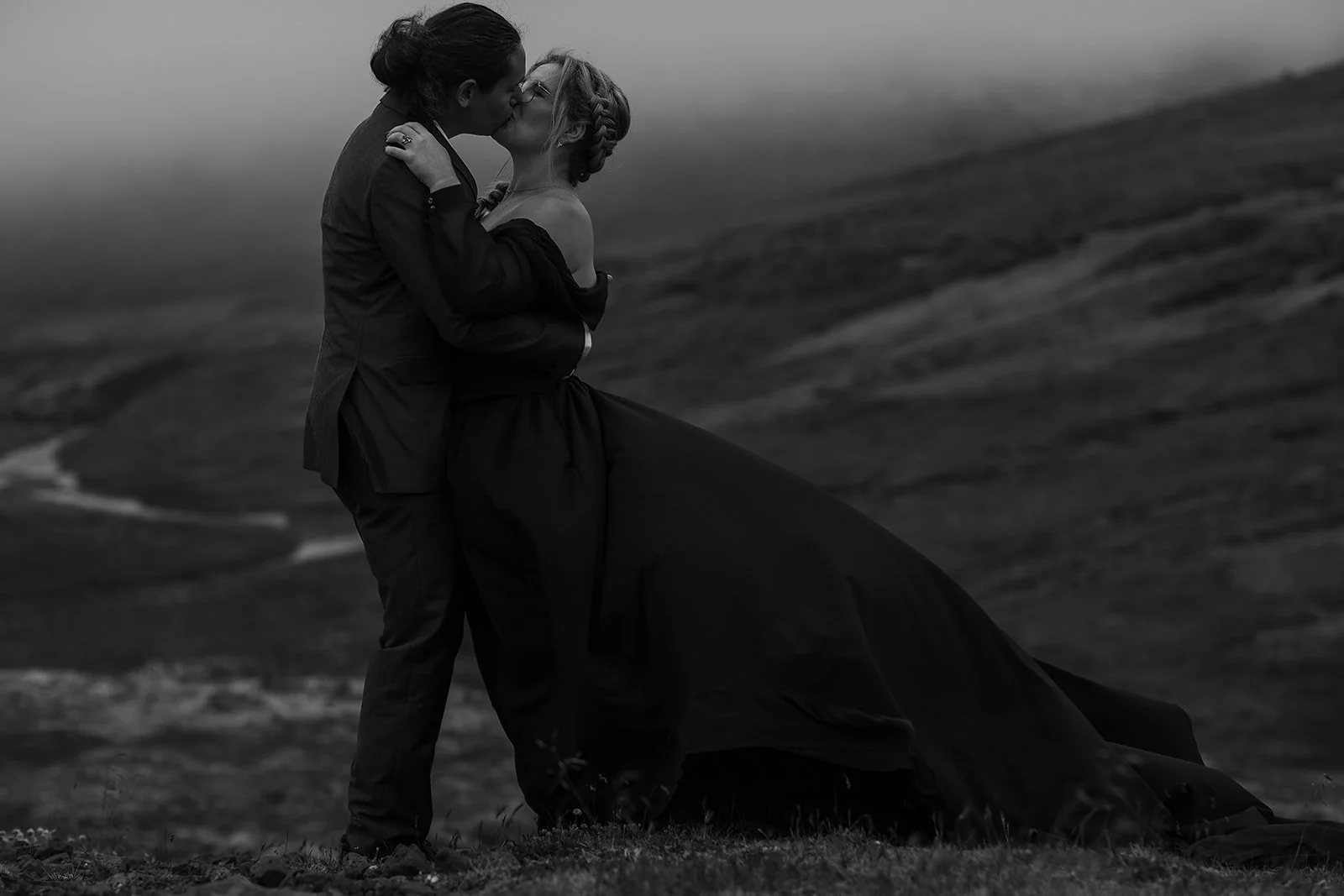 Alternative Iceland elopement couple wearing black wedding dress and purple hair — couple portraits at mountain