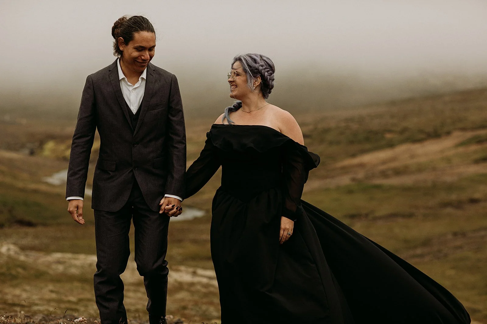 Alternative Iceland elopement couple wearing black wedding dress and purple hair — couple portraits at mountain