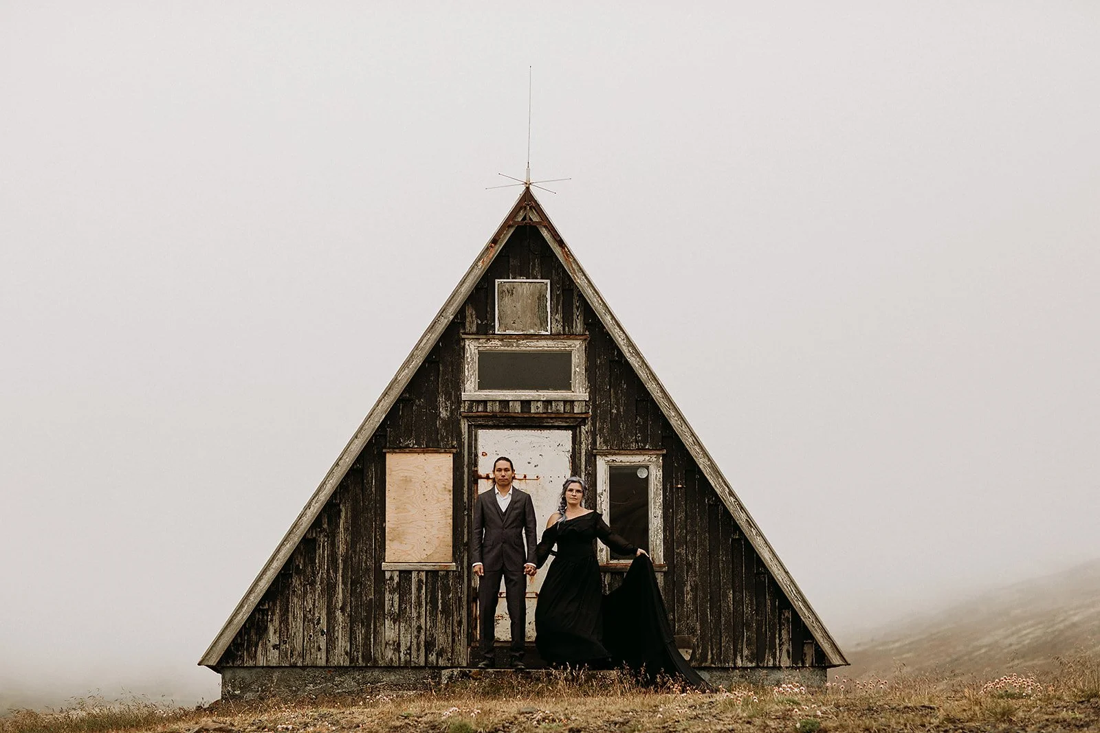 Alternative Iceland elopement couple wearing black wedding dress and purple hair — couple portraits at mountains