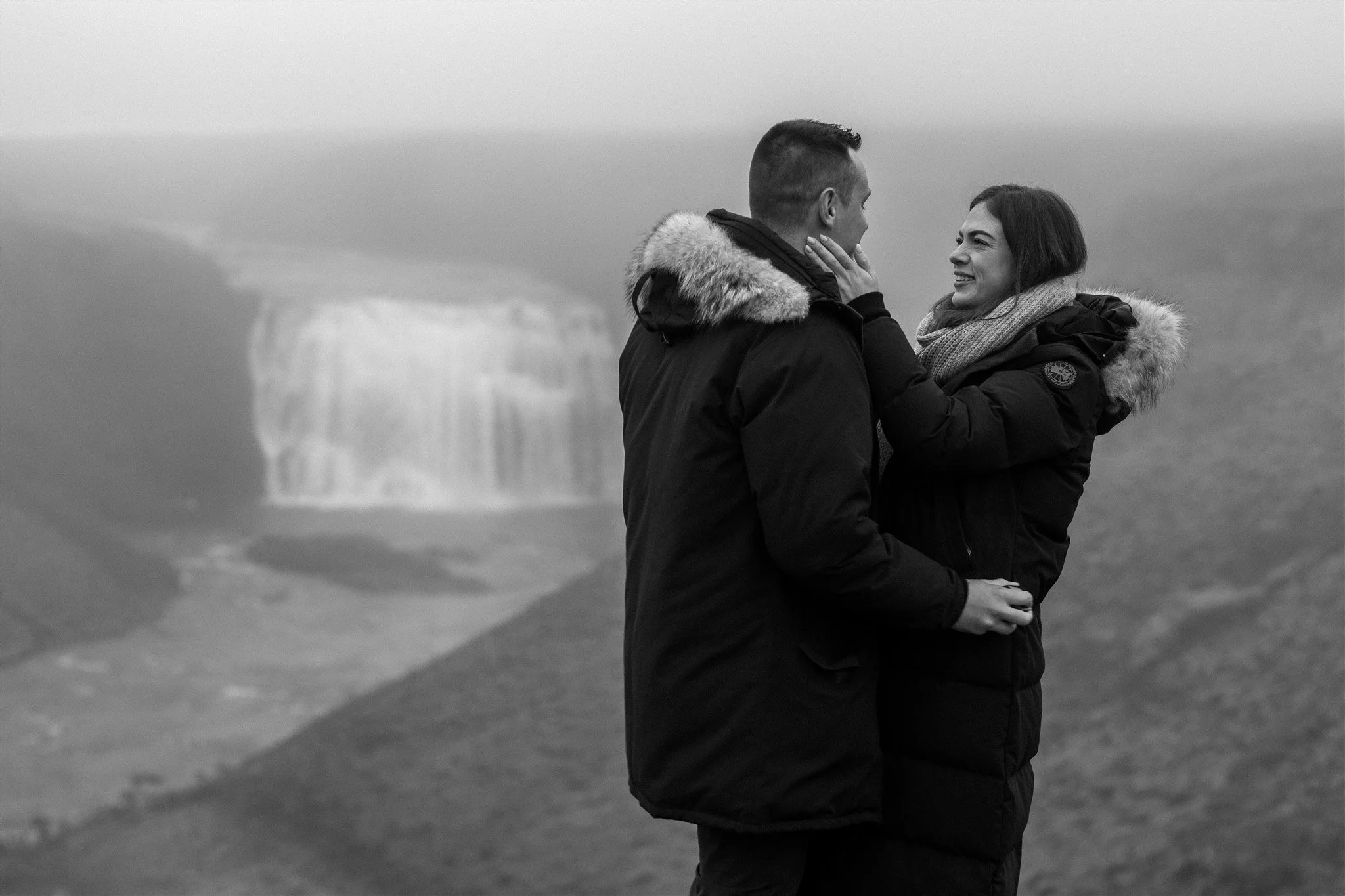  Secret Iceland Proposal at a Foggy Winter Waterfall by a local Iceland Engagement &amp; Proposal Photographer and planner —couple hugs 