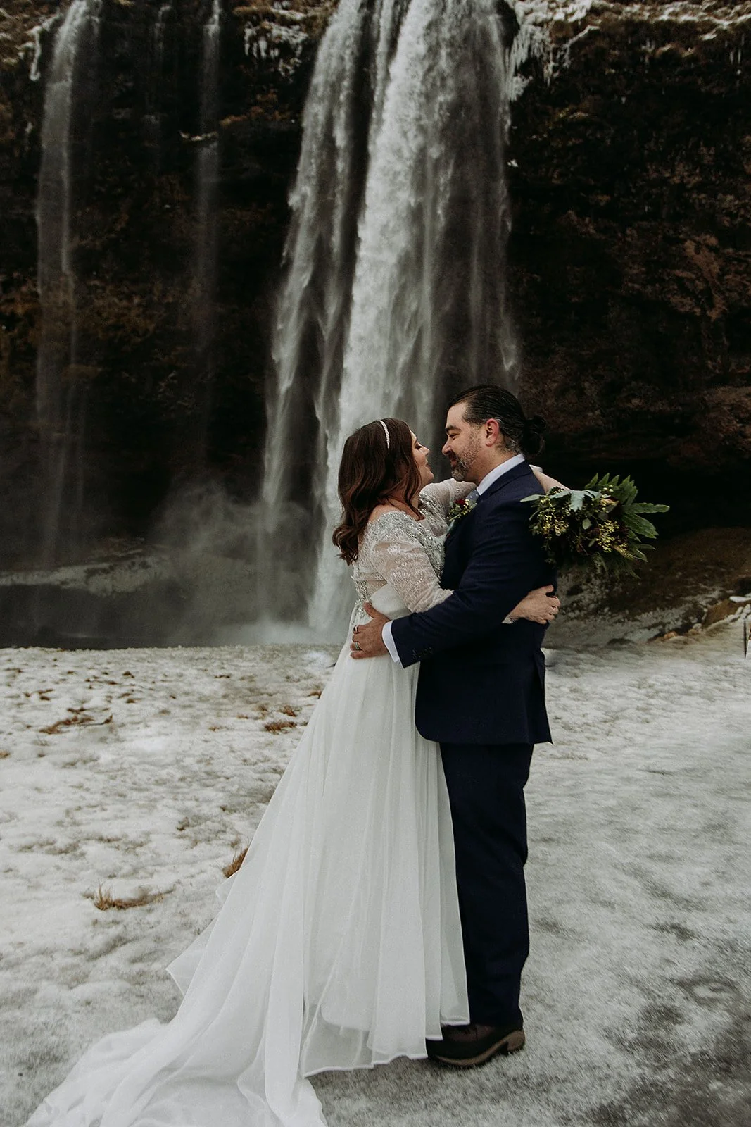 A Winter Iceland Elopement at Skógafoss (Skogafoss) and Glacier — couple in front of the waterfall