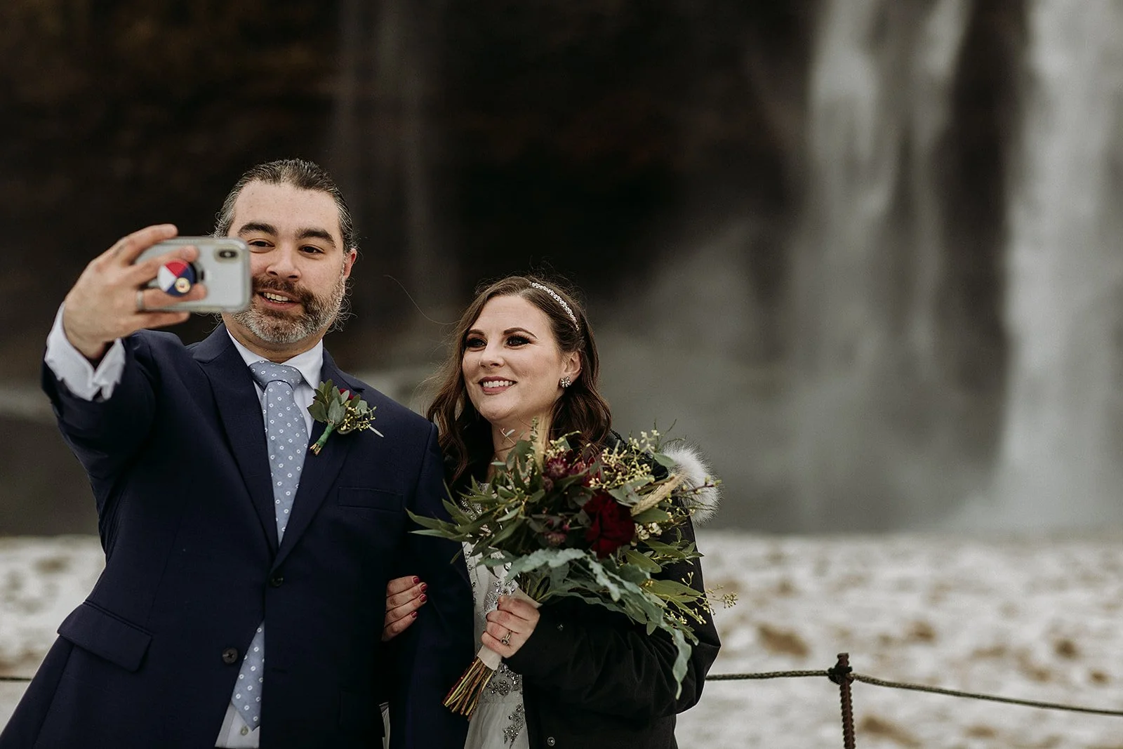 A Winter Iceland Elopement at Skógafoss (Skogafoss) and Glacier — couple in front of the waterfall