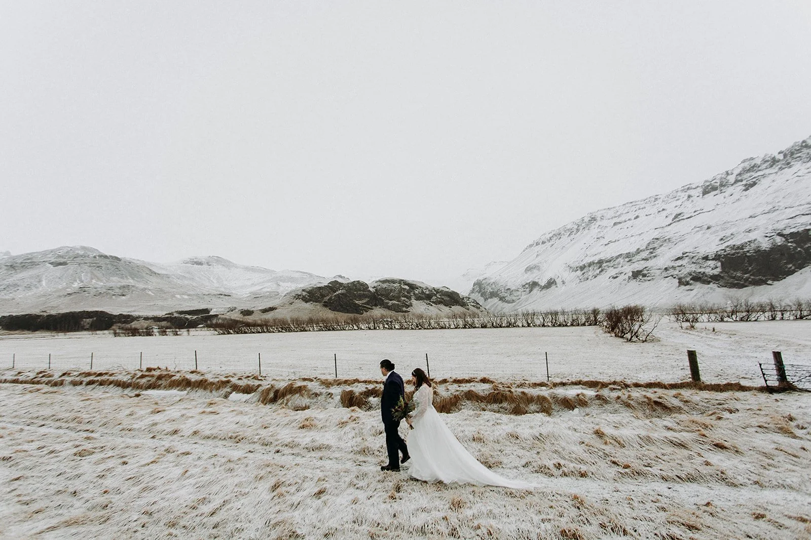A Winter Iceland Elopement at Skógafoss (Skogafoss) and Glacier — couple in front of mountains