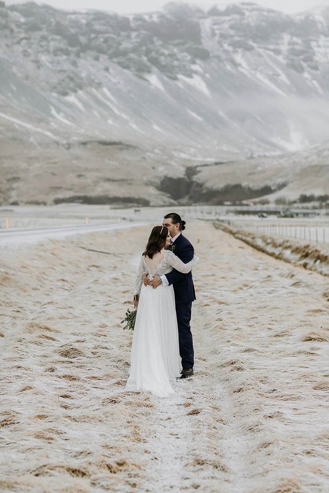 A Winter Iceland Elopement at Skógafoss (Skogafoss) and Glacier — couple in front of mountains